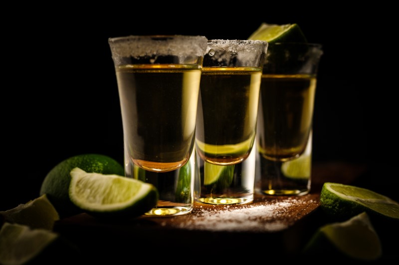 Three shots of tequila with limes and salt