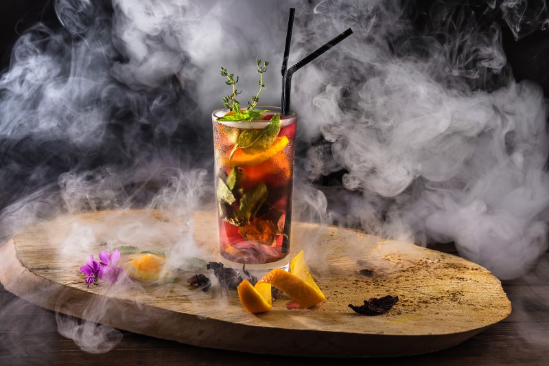 Smokey setup of colorful mixed drink on wood