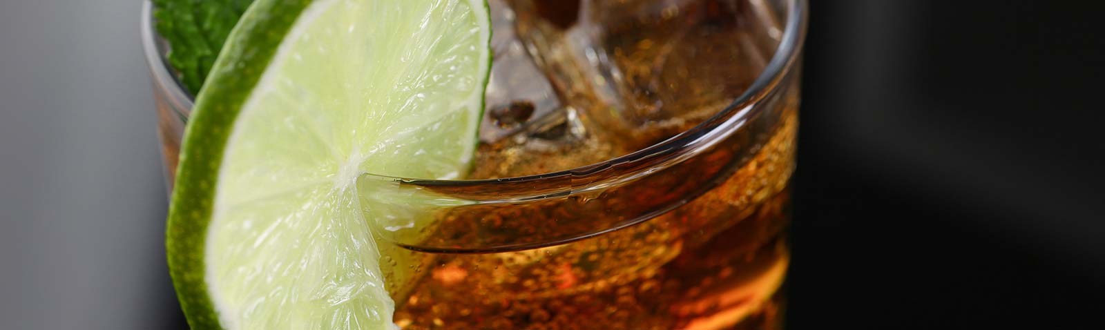 Closeup of rum with a lime wedge on the glass